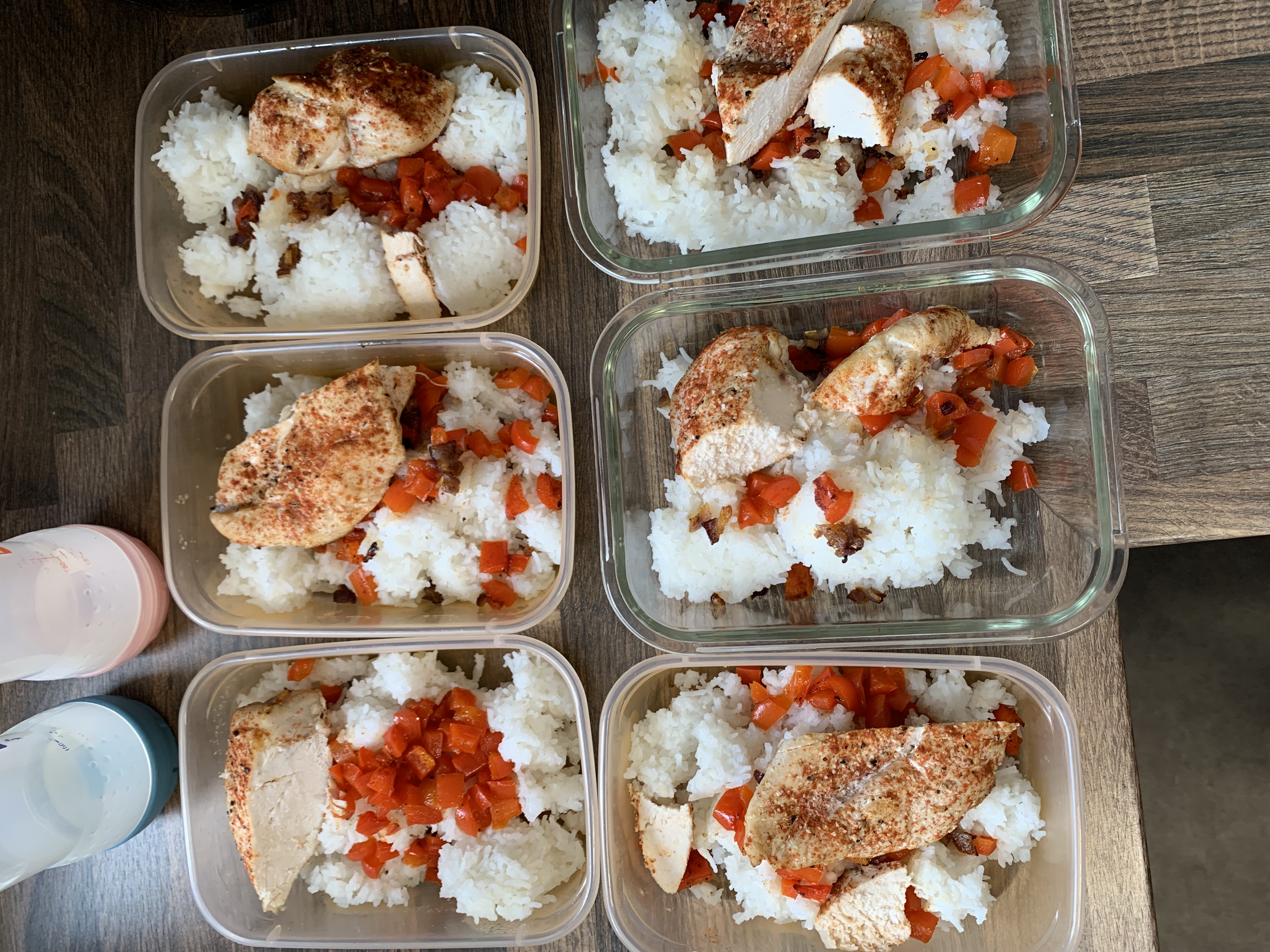 Five containers of chicken, rice and vegetables lined up