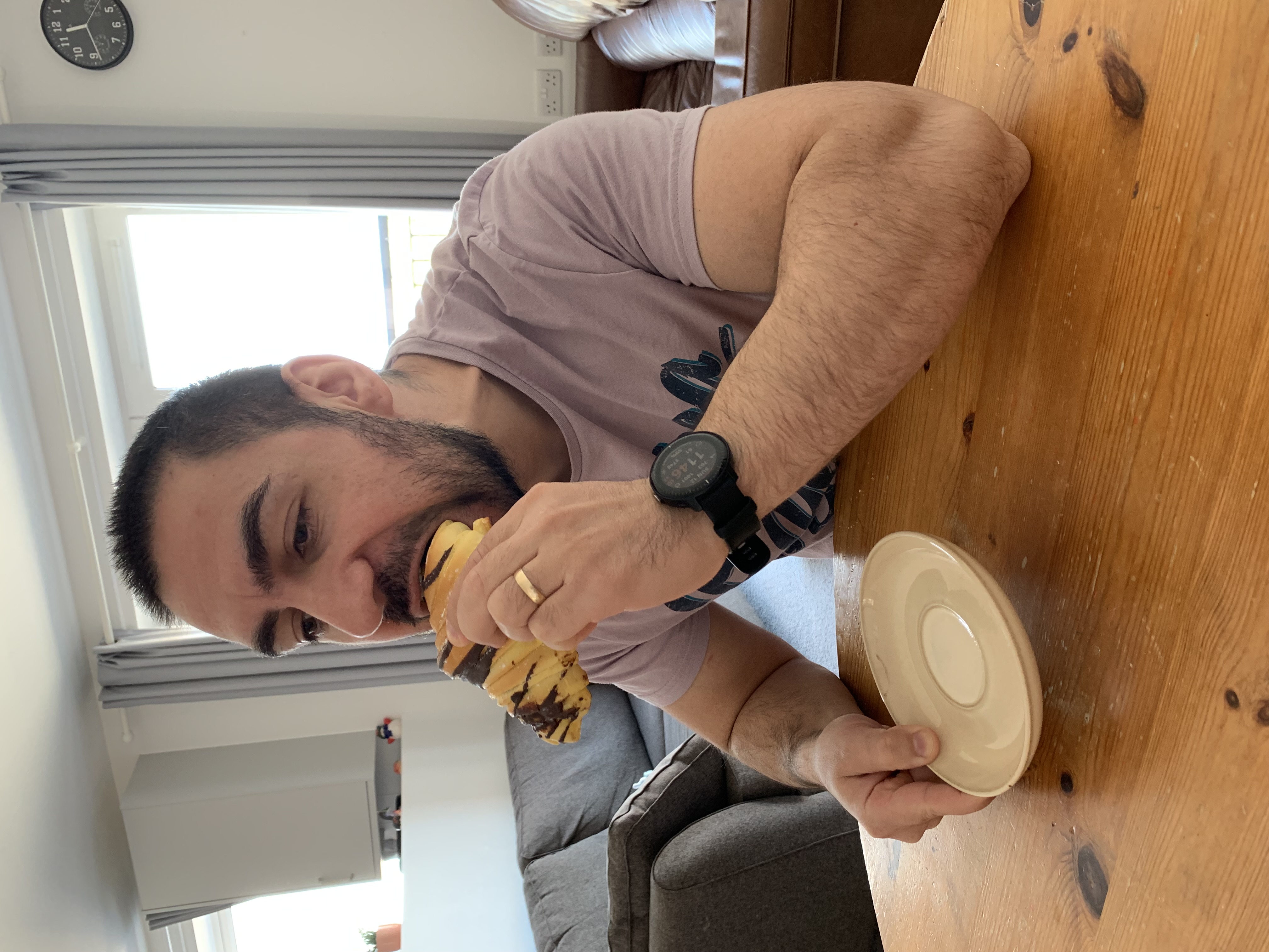 Taking a bite of a chocolate pastry at the table